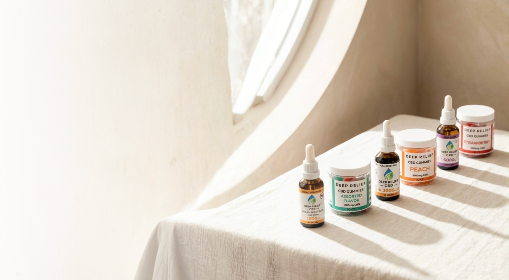 Deep Relief tinctures and gummies on white draped cloth in warm natural sunlight.